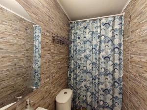 a bathroom with a shower curtain and a toilet at Cabañas altos de Mirasol in Puerto Montt