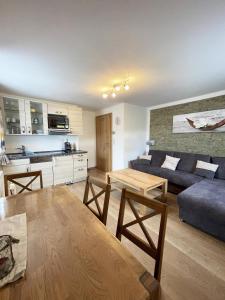 a living room with a couch and a table at Ferienwohnung Schildwolf in Fieberbrunn