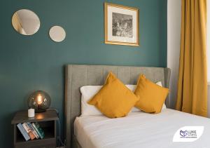 um quarto com uma cama com almofadas amarelas em Luke Stays - Ashdown em Durham