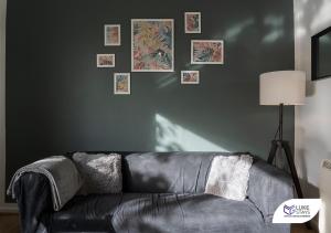 um sofá de couro preto numa sala de estar com fotografias na parede em Luke Stays - Ashdown em Durham