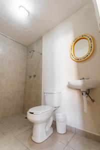 a bathroom with a toilet and a sink and a mirror at Hotel Meson de Isabel in Querétaro