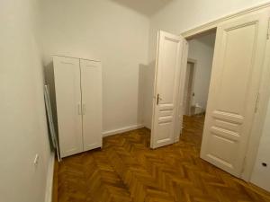 une chambre vide avec deux portes blanches et du parquet dans l'établissement Vienna Living Apartments - Gumpendorfer Straße, à Vienne