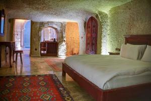 a bedroom with a bed and a room with a door at Calypso Cave Suites in Ürgüp