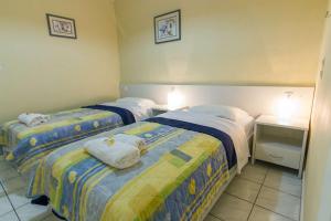 Dos camas en una habitación de hotel con toallas. en Stathopoulos Apartments, en Sampatiki