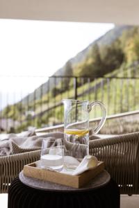 a glass pitcher of lemonade on a tray with a spoon at Culinaria living in Tirolo