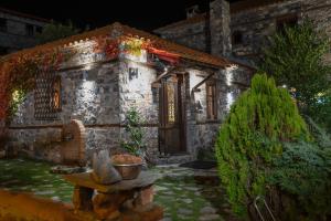 een stenen huis met een tafel ervoor bij 4 Seasons Premium Chalet in Palaios Agios Athanasios