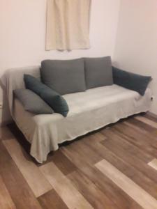 ein Sofa mit zwei Kissen auf einem Zimmer in der Unterkunft - La Maison des Bois - in Les Bréviaires
