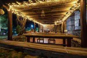 een houten terras met 's nachts verlichting bij 4 Seasons Premium Chalet in Palaios Agios Athanasios
