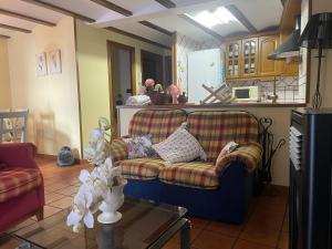 uma sala de estar com um sofá e uma mesa em CASA RURAL SAN JULIAN em Villahermosa del Río