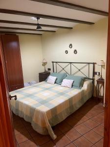 um quarto com uma cama com duas almofadas em CASA RURAL SAN JULIAN em Villahermosa del Río