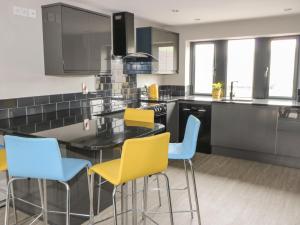 a kitchen with a table and yellow chairs at Vista Tasso in Holmfirth