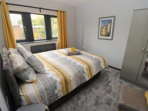 una camera da letto con un letto con un piumone e una finestra di Vista Tasso a Holmfirth