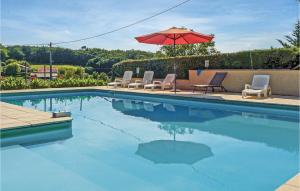 a swimming pool with chairs and an umbrella at Les Marronniers in Bourgougnague +18 photos