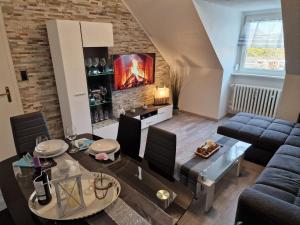 a living room with a couch and a table at Exklusives und helles Dachgeschoss-Apartment No 1 im Zentrum von Kassel, schnelles 1Gbit Internet, Geschirrspüler, Boxspringbetten in Kassel