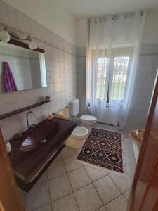 baño con lavabo y aseo y ventana en Casa Bellavista, en Neive