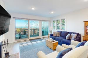 a living room with a blue couch and a large window at Sandpiper 1 in Glen Arbor