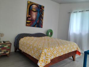 um quarto com uma cama com um quadro na parede em Casas Guaney em Manuel Antonio