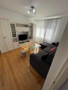 a living room with a black couch and a table at Apartament Anca in Gura Humorului