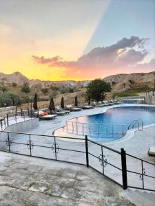 ein großer Pool mit einem Zaun um ihn herum in der Unterkunft MDC Cave Hotel Cappadocia in Ürgüp