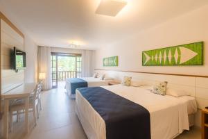 um quarto de hotel com duas camas e uma mesa em Corais e Conchas em Búzios