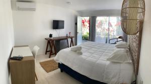 a bedroom with a bed and a desk and a window at Brisas de Centenario in Paso de los Toros +17 photos