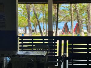 a table and chairs sitting in front of a window at Chalé Jorai - pé na areia in Bertioga
