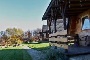 a porch of a cabin with a table and chairs at Bies-Czaderskie Chaty in Ustrzyki Dolne