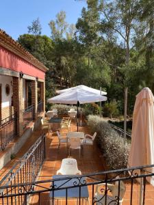 a patio with an umbrella and tables and chairs at Albergue Rural de Fuente Agria in Villafranca de Córdoba