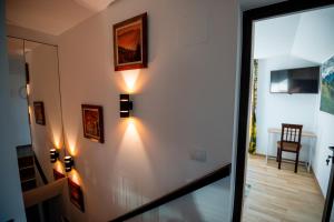 a hallway with lights on a white wall at Hanul Doctorului Badeni-Runcu in Runcu +105 photos