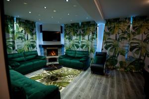 a living room with green couches and a fireplace at Hanul Doctorului Badeni-Runcu in Runcu