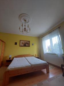 1 dormitorio con cama y lámpara de araña en schönes Ferienhaus mit grossem Pool 4 km zum Balaton, en Balatonszentgyörgy