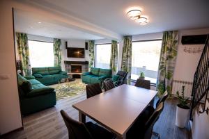 sala de estar con mesa y muebles verdes en Hanul Doctorului Badeni-Runcu, en Runcu