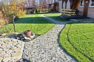 a garden with a stone walkway next to a house at Bies-Czaderskie Chaty in Ustrzyki Dolne