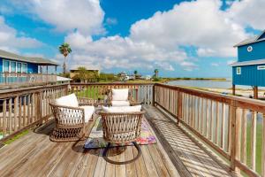 een terras met stoelen en een huis en het water bij Flamingo Lagoon in Corpus Christi