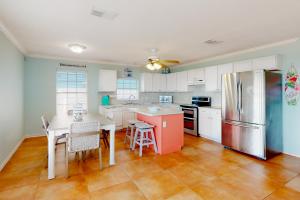een keuken met een tafel en een koelkast bij Flamingo Lagoon in Corpus Christi