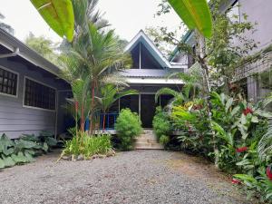 uma casa com um monte de plantas à frente dela em Casas Guaney em Manuel Antonio