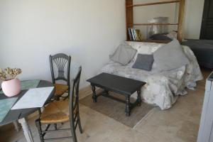 a room with a table and a bed and a table and chairs at Au coeur des landes in Carneville