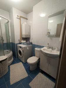 ein Badezimmer mit einem Waschbecken und einer Waschmaschine in der Unterkunft Feel's like Home in Sarajevo