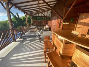 a large deck with chairs and a table on it at Villa panoramique à Pointe-Noire avec vue sur mer et piscine in Pointe-Noire