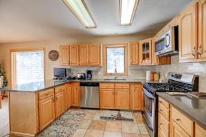 une cuisine avec des armoires en bois et des appareils en acier inoxydable dans l'établissement Blue River Escape Home: Peaceful, On River, à Breckenridge