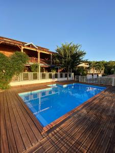 a large swimming pool on a wooden deck at Appartement charmant à Pointe-Noire, vue mer, 51 m², piscine in Pointe-Noire