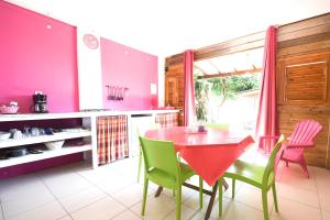 ポワント・ノワールにあるCharmant appartement à Pointe-Noire 51 m² avec piscine partageeのキッチン(赤いテーブル、緑の椅子付)