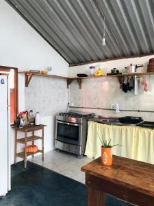 a kitchen with a stove and a table in it at Morada Cacauêra in Itacaré