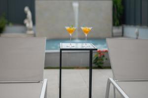 two wine glasses sitting on a table next to two chairs at Gold Coast Photography Inn in Estoril