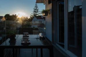 a table on a balcony with a view of the sunset at Gold Coast Photography Inn in Estoril