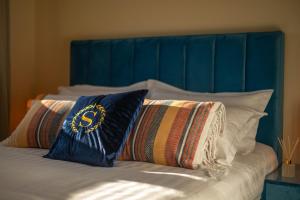 two pillows on a bed with a blue headboard at Gold Coast Photography Inn in Estoril