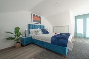 a bedroom with a blue bed and a potted plant at Gold Coast Photography Inn in Estoril