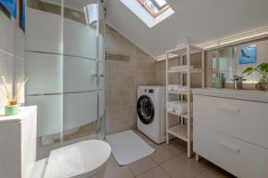 a bathroom with a toilet and a washing machine at Gold Coast Photography Inn in Estoril