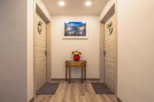 a hallway with two doors and a table with flowers on it at Gold Coast Photography Inn in Estoril