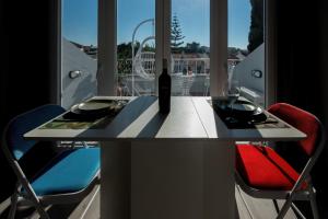a table with a bottle of wine and two chairs at Gold Coast Photography Inn in Estoril